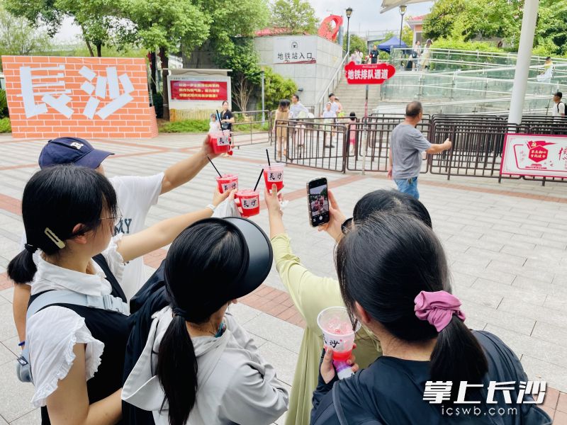游客小姐姐高举果汁，自拍为长沙点赞。