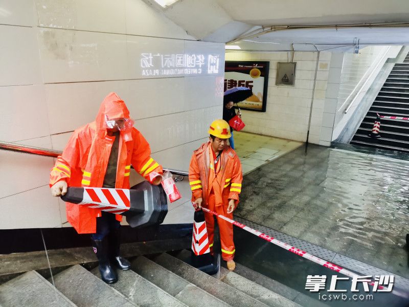 开福区环卫工人迅速处理地下通道积水，并设置警示标志。 长沙晚报通讯员 向薇 供图